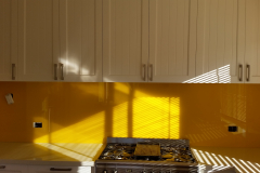 Graphic Glass Services vibrant yellow splashback being installed