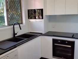 Stunning White Colourback Glass Kitchen Splashback by Graphic Glass Services Qld paired with black accessories