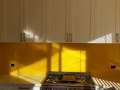 Graphic Glass Services vibrant yellow splashback being installed